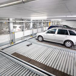 A car is being lowered on a parking system