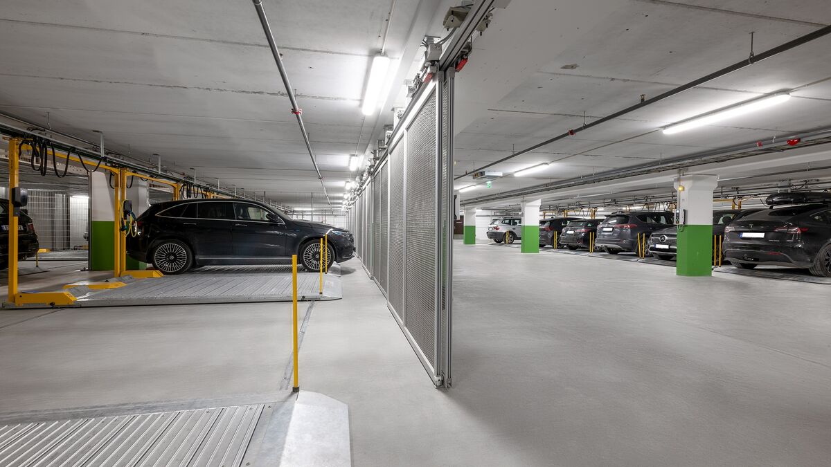 Plataforma de aparcamiento WÖHR 601 en un garaje subterráneo con varios vehículos sobre plataformas móviles para un aprovechamiento óptimo del espacio de estacionamiento disponible.