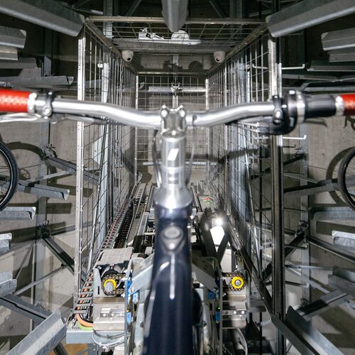 The bicycle is secured in a rail within the parking system