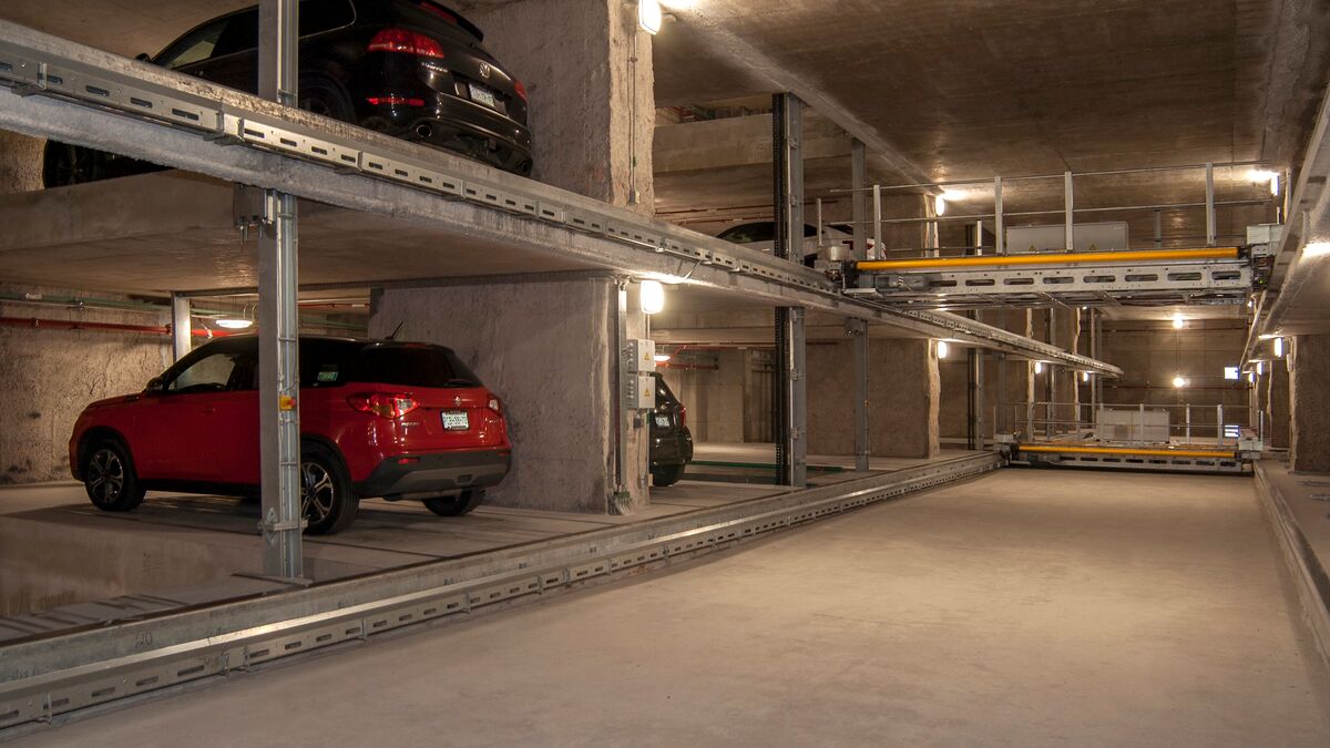 La voiture est garée sur une palette de stationnement dans un système de parking à étagères