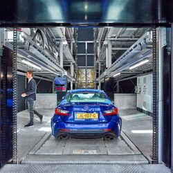 Blaues Auto steht in der Einfahrtskabine eines Autoparksystems