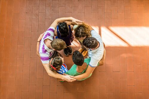 Des personnes forment un cercle et s'étreignent