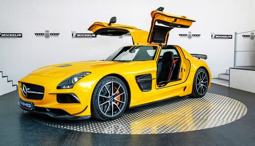 Gelbes Auto mit offenen Türen steht auf einer Drehplatte