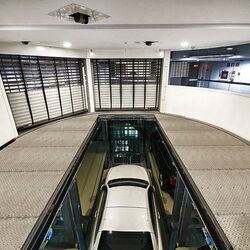 La voiture se trouve dans une cabine d'entrée, sur une plate-forme de stationnement, et descend