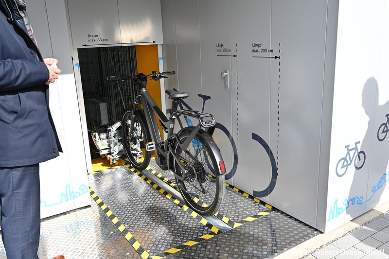 Bicicleta sobre un riel delante de un sistema automático de aparcamiento de bicicletas