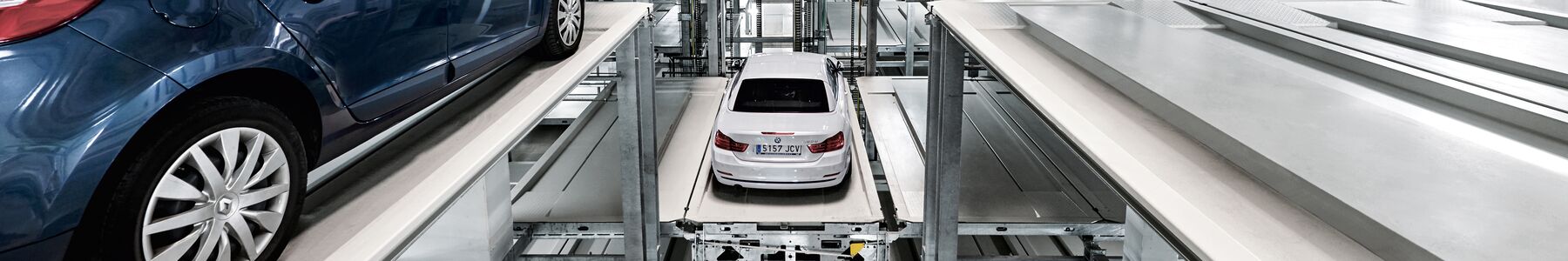 La voiture est garée sur une palette de stationnement dans un système de parking à étagères