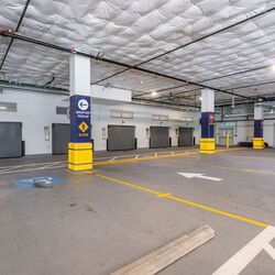 L’image montre l’entrée d’un système de stationnement automatisé dans un parking souterrain moderne avec plusieurs portes d’accès.