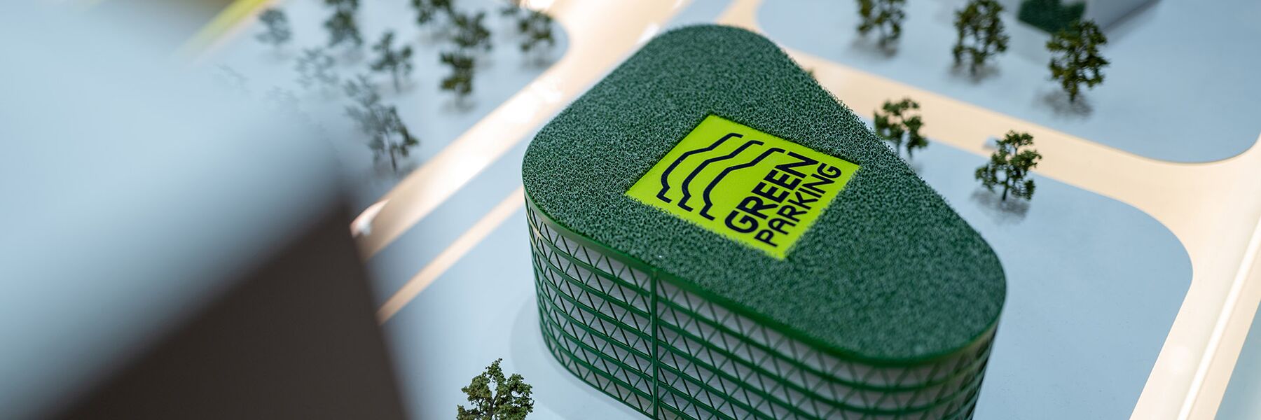 Detalle de una maqueta urbana con un edificio de fachada verde