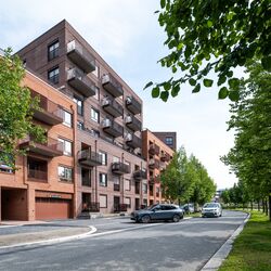 Complejo residencial moderno donde un vehículo entra en un garaje equipado con un sistema de aparcamiento integrado.