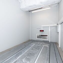 L’image montre la zone de transfert vide d’un système de stationnement automatisé, où les véhicules sont positionnés avant leur stockage automatique.