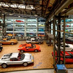 Una estantería en la pared llena de coches en un museo