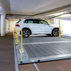 Plataforma de aparcamiento con un coche estacionado sobre ella en un aparcamiento subterráneo