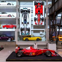 Une étagère murale remplie de voitures dans un musée