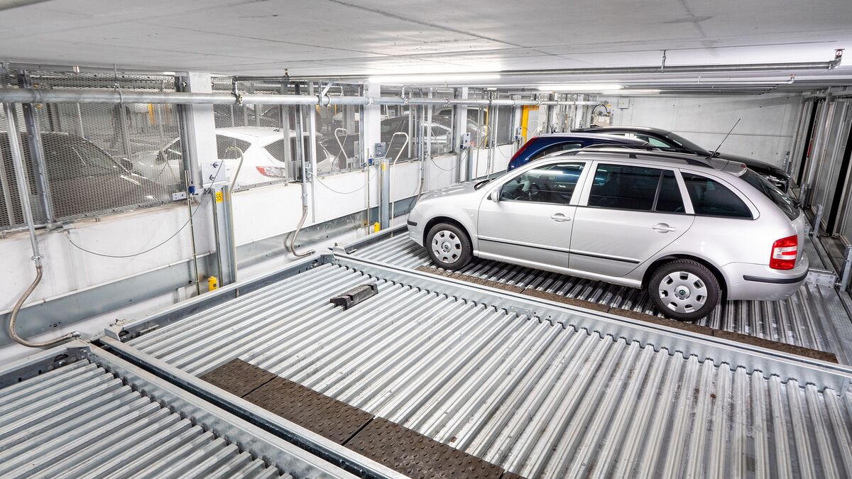 A car is being lowered on a parking system