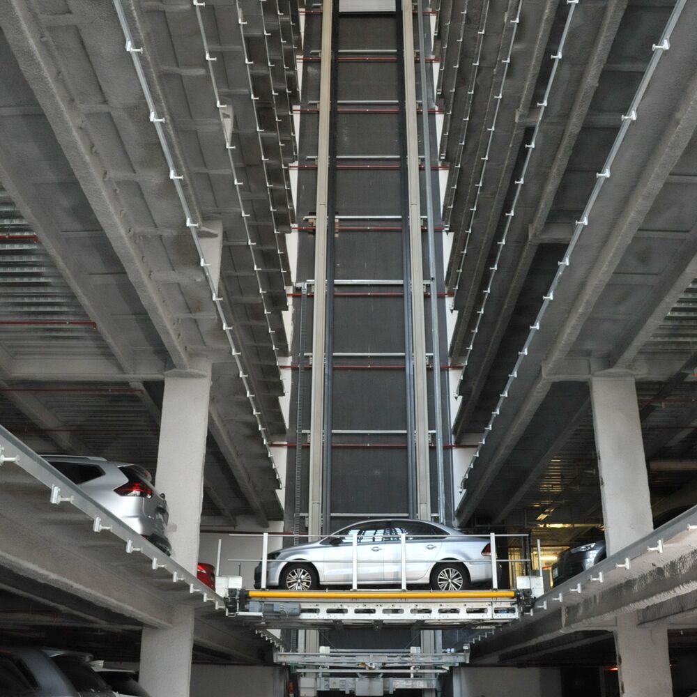 The car is parked on a parking pallet in a multi-storey car park system