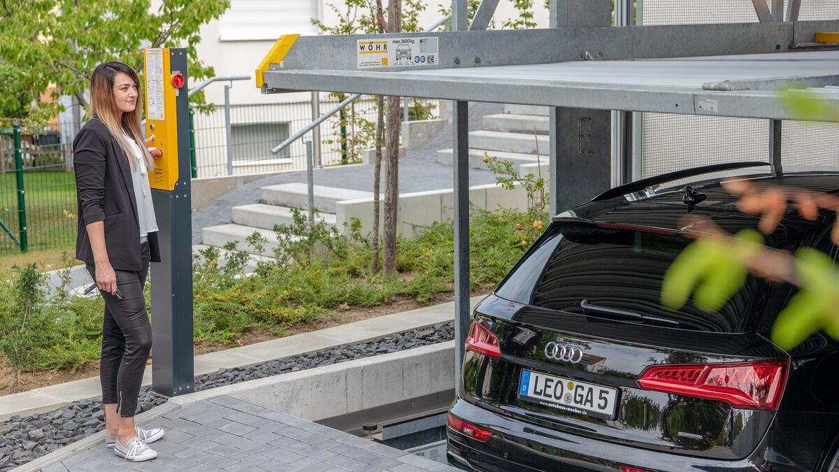 Frau bedient ein Autoparksystem
