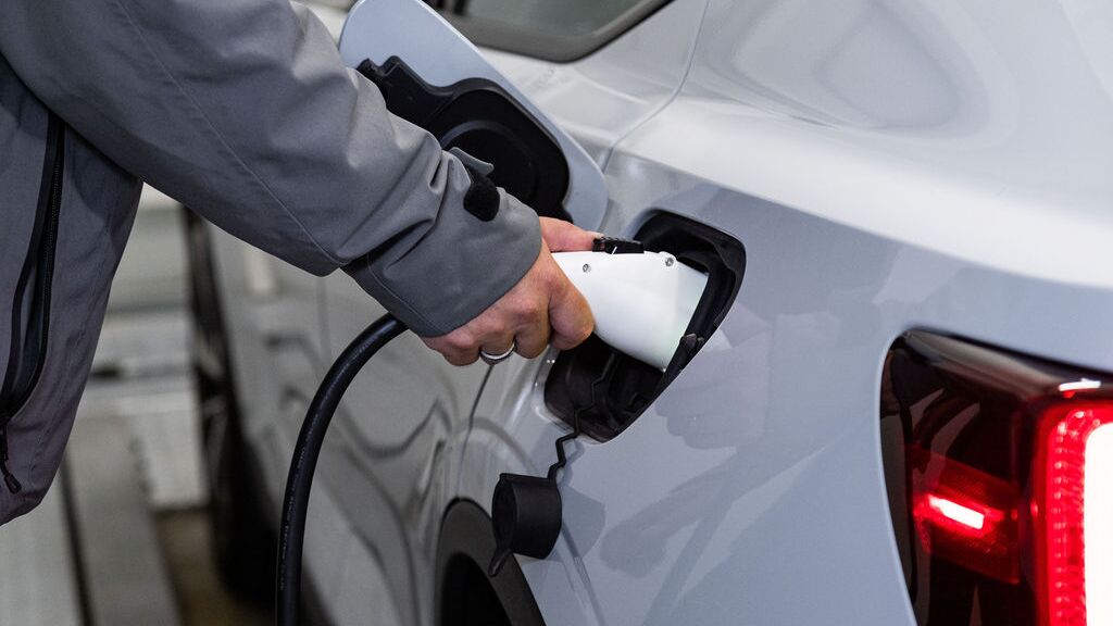 L’image montre le processus de recharge d’un véhicule électrique, au cours duquel un connecteur de recharge est branché au véhicule afin de recharger la batterie pendant le processus de stationnement.