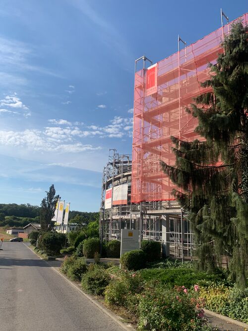 Vista exterior del edificio de la empresa WÖHR Autoparksysteme GmbH con andamios
