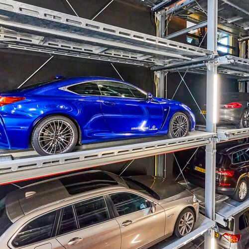 La voiture est garée sur une palette de stationnement dans un système de parking à étagères