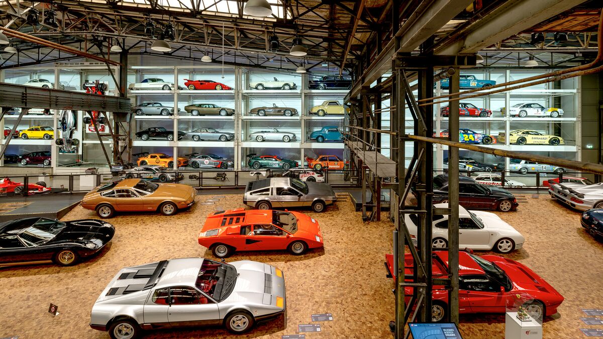 Una estantería en la pared llena de coches en un museo