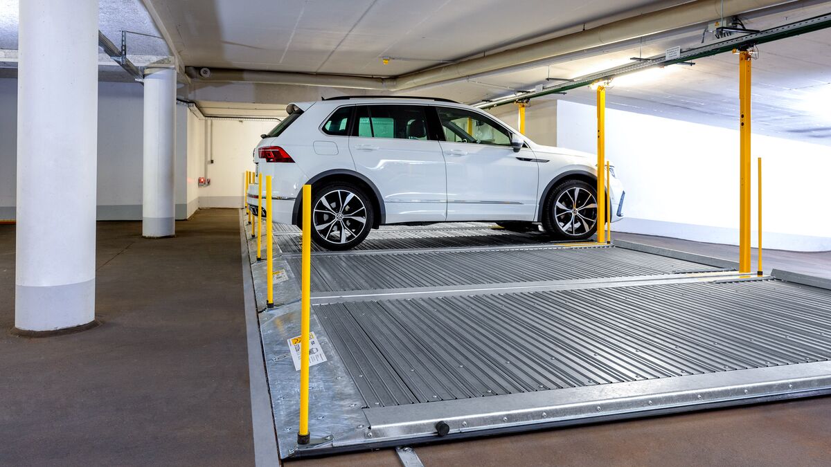 Plataforma de aparcamiento con un coche estacionado sobre ella en un aparcamiento subterráneo