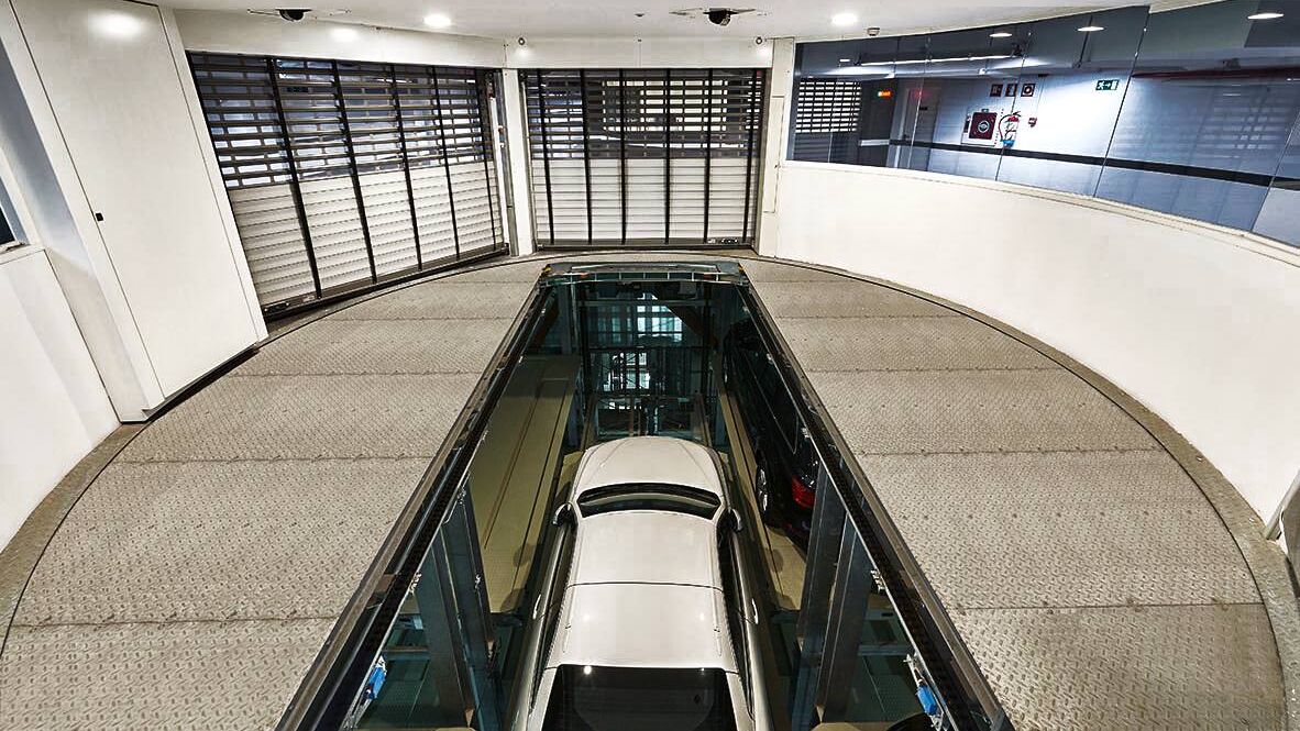 La voiture se trouve dans une cabine d'entrée, sur une plate-forme de stationnement, et descend