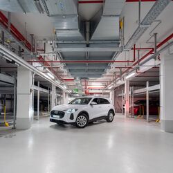 La voiture est garée dans l'allée du parking souterrain, entre deux systèmes Combilift