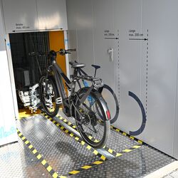Vélo sur un rail devant un système de stationnement automatique pour vélos