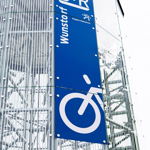 Cartel en la fachada de una torre de aparcamiento automático para bicicletas