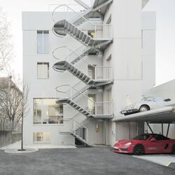 Edificio en la calle Olgastraße con un sistema de aparcamiento para coches instalado delante