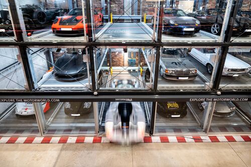 Un sistema de aparcamiento con varios coches, ordenadamente alineados junto a una pared del museo