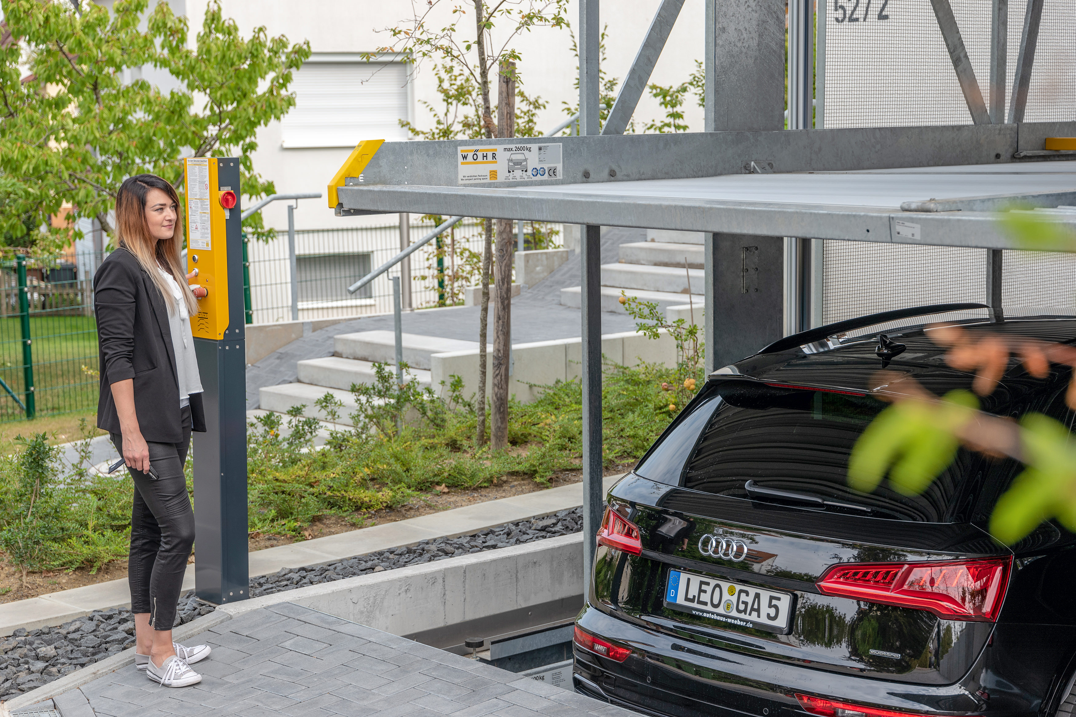 A woman operates a car parking system